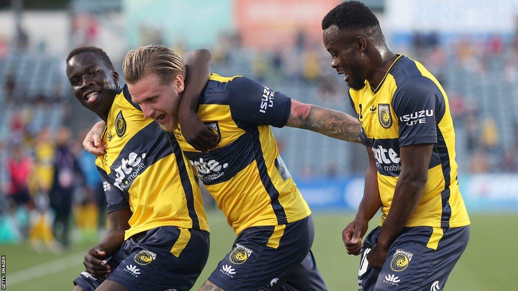 Jason Cummings (centre) celebrates scoring for Central Coast Mariners