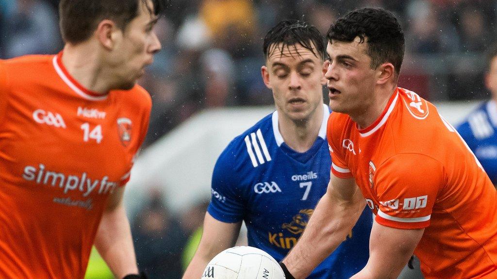 Armagh defender Conor O'Neill holds onto possession despite damp conditions in Breffni Park