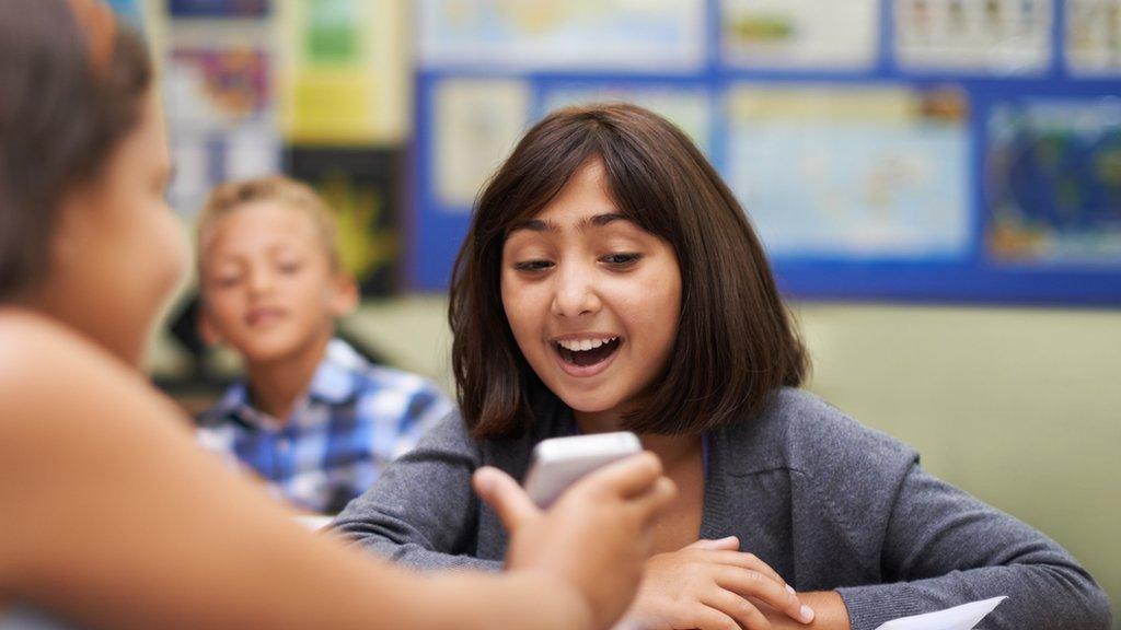 A girl looking at a phone screen in school