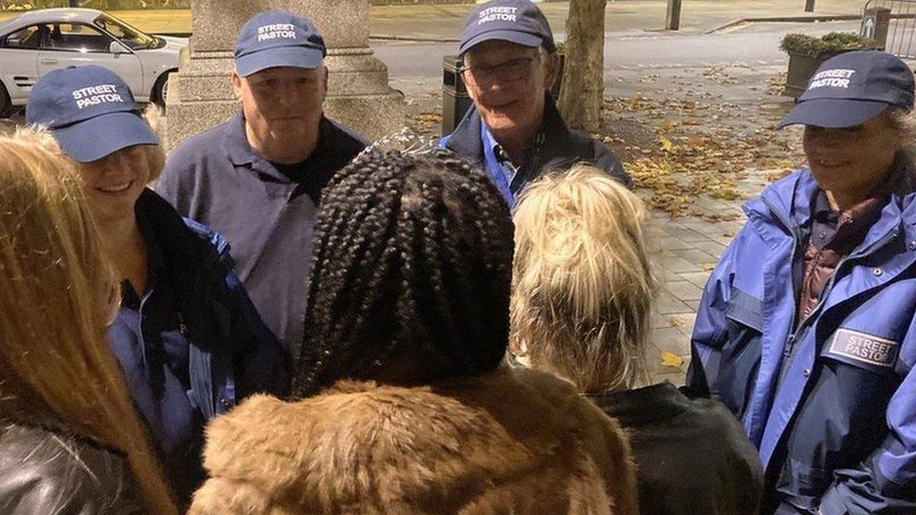 Street Pastors talking to three young women at Market Square, Salisbury