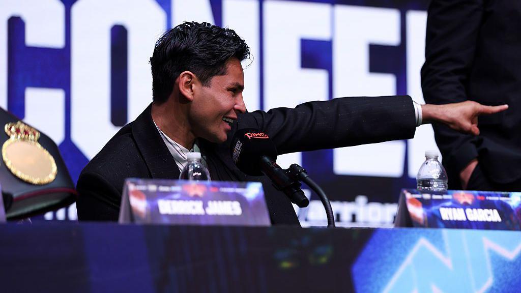Ryan Garcia points and shouts at a news conference