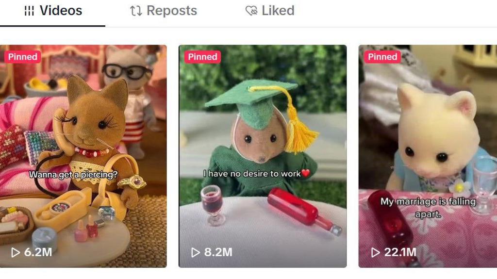A screenshot of the Sylvanian Drama TikTok account showing three videos. The first is of a Sylvanian Families fluffy cat with the words 'Wanna get a piercing?' The second is of a mouse wearing a green graduation outfit with the words 'I have no desire to work'. The third is of a cat looking at a bottle of wine that has fallen over with the words 'My marriage is falling apart.'