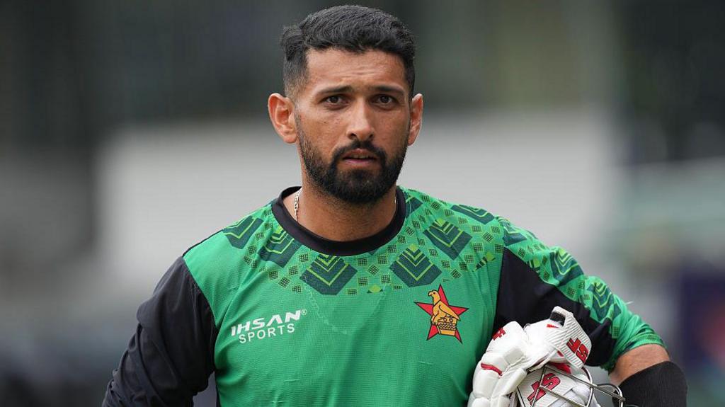 Zimbabwe's Sikandar Raza carries his batting gloves and his helmet under his arm during a practice session