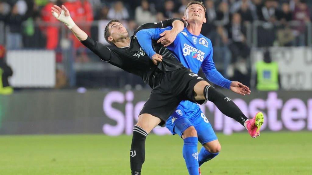 Liam Henderson battles with Juventus forward Dusan Vlahovic