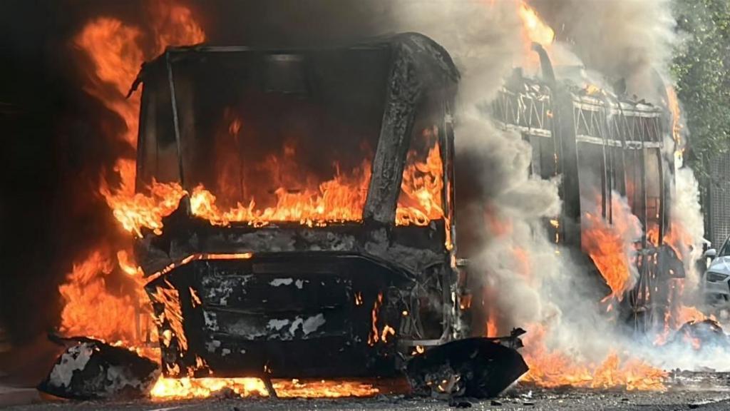 A destroyed bus on fire 