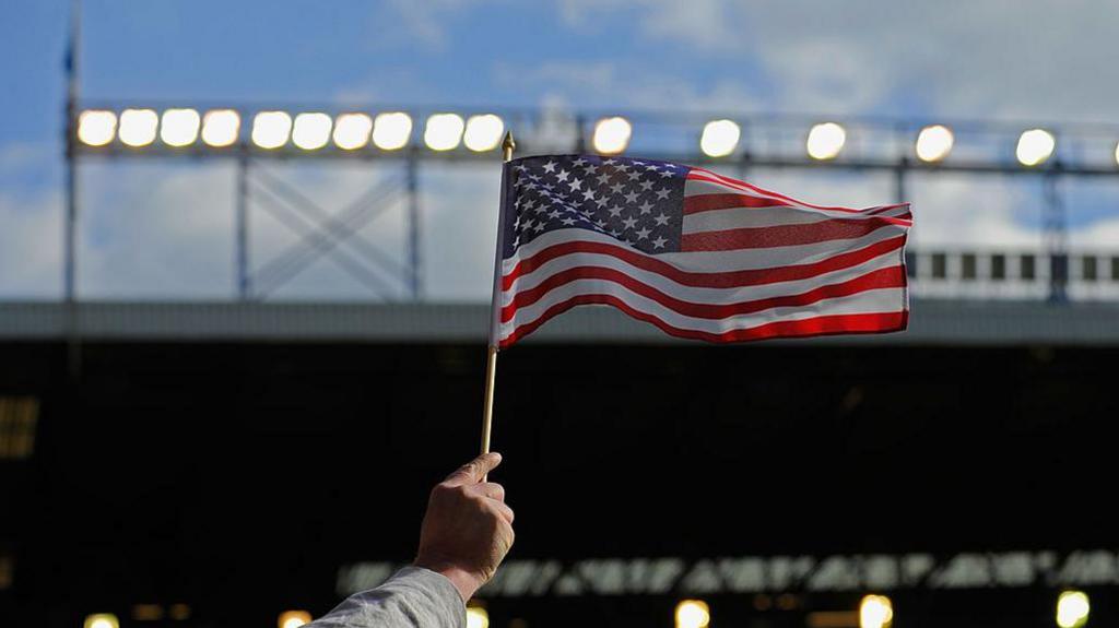 An American flag held up at a football stadium