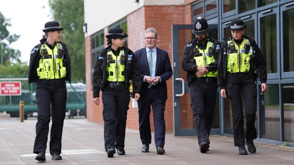 Prime Minister walks with police officers