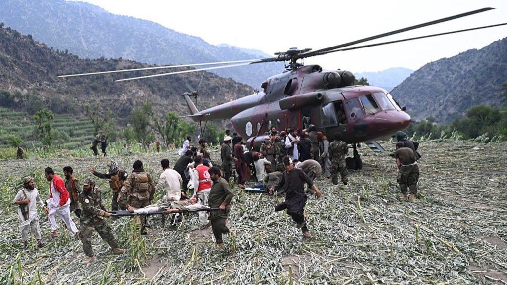 Rescuers load an earthquake survivor onto a helicopter