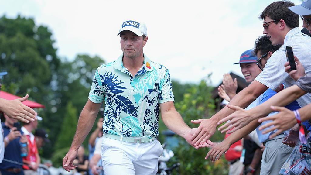 Viktor Hovland of Norway high fives fans while walking towards the first tee box during the final round of the 2026 Travelers Championship