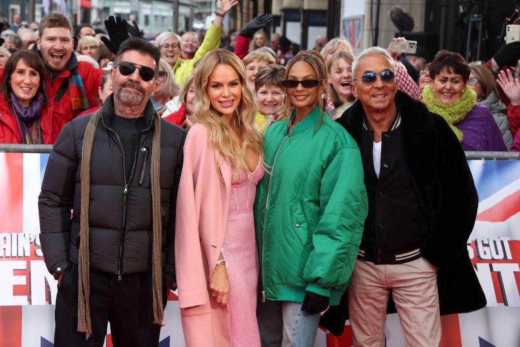 Simon Cowell, Amanda Holden, Alesha Dixon and Bruno Tonioli posing at a Britain's got Talent red carpet event with cheering crowds behind them