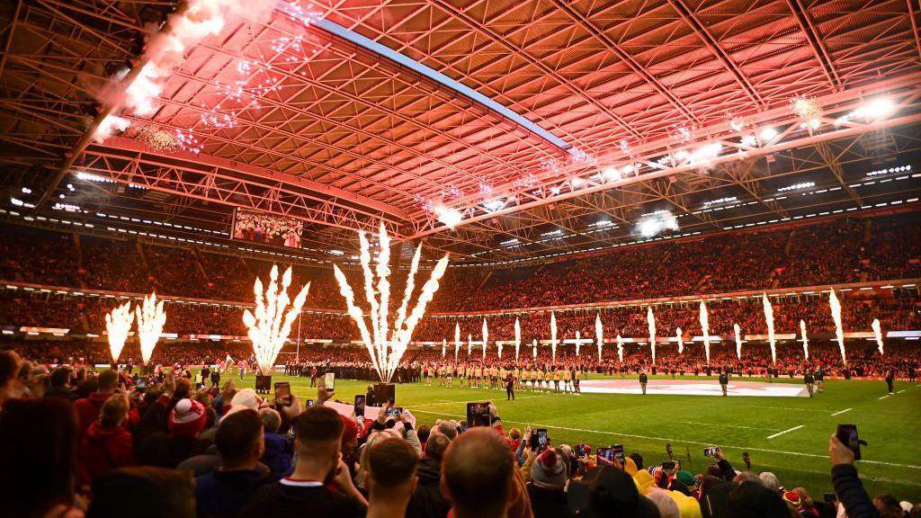 Crowds watch fire displays inside the Principality Stadium