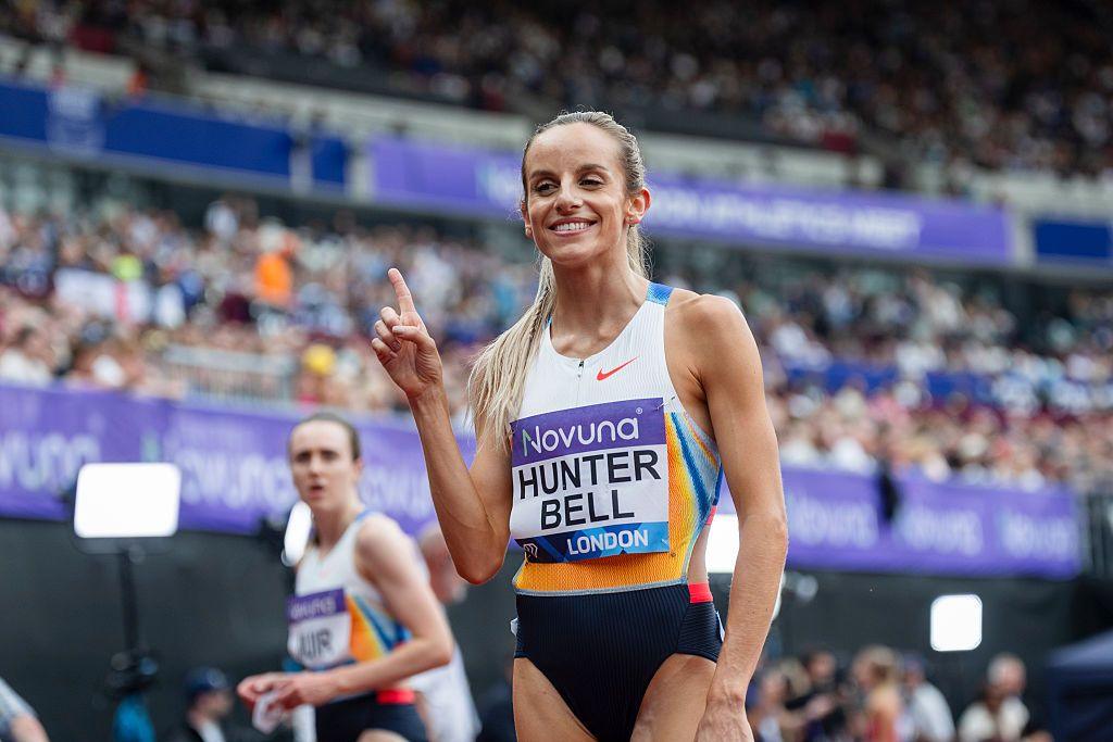 Georgia Hunter-Bell makes a number one hand gesture while smiling after a race with the crowd in the background.