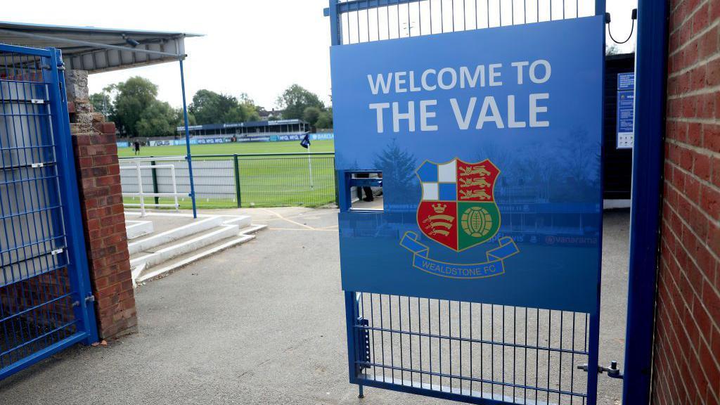 An image showing the front gate at Grosvenor Vale stadium, with the pitch in the background.