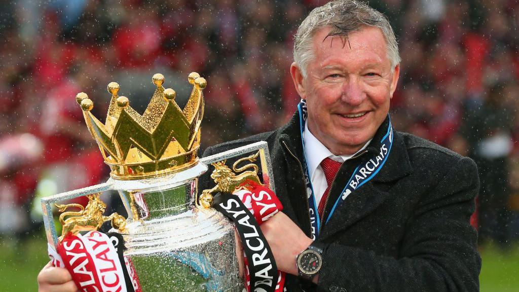 Sir Alex Ferguson holding the Premier League trophy