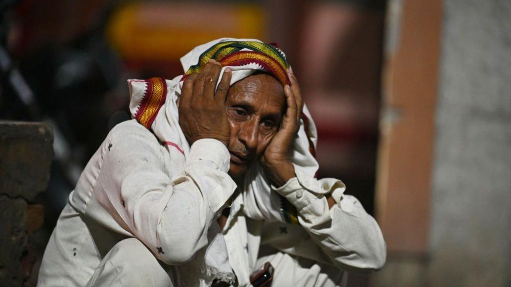 A relative grieves for a loved one outside the morgue of a hospital in Hathras