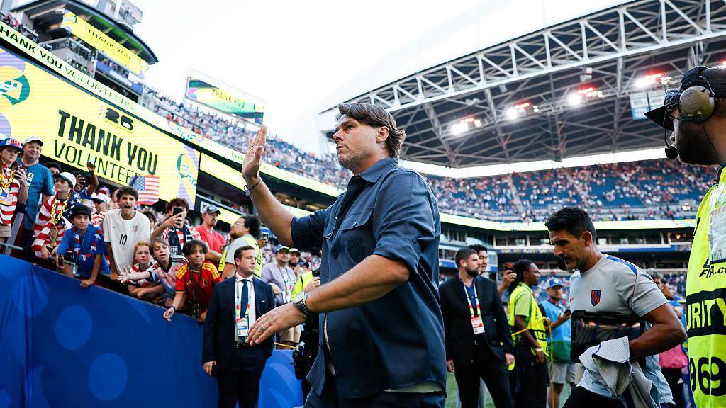 Mauricio Pochettino waves to fans as he leaves the pitch