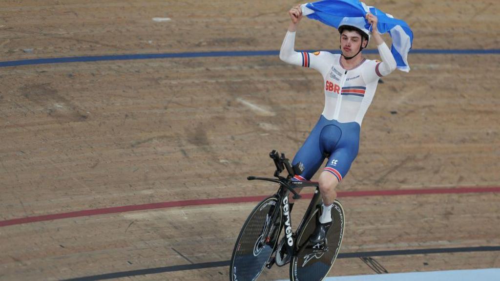 Fin Graham celebrates a win in Glasgow by holding the Scottish flag