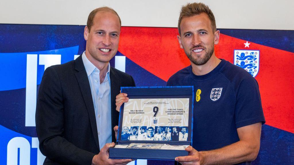 Prince William giving Harry Kane a football shirt