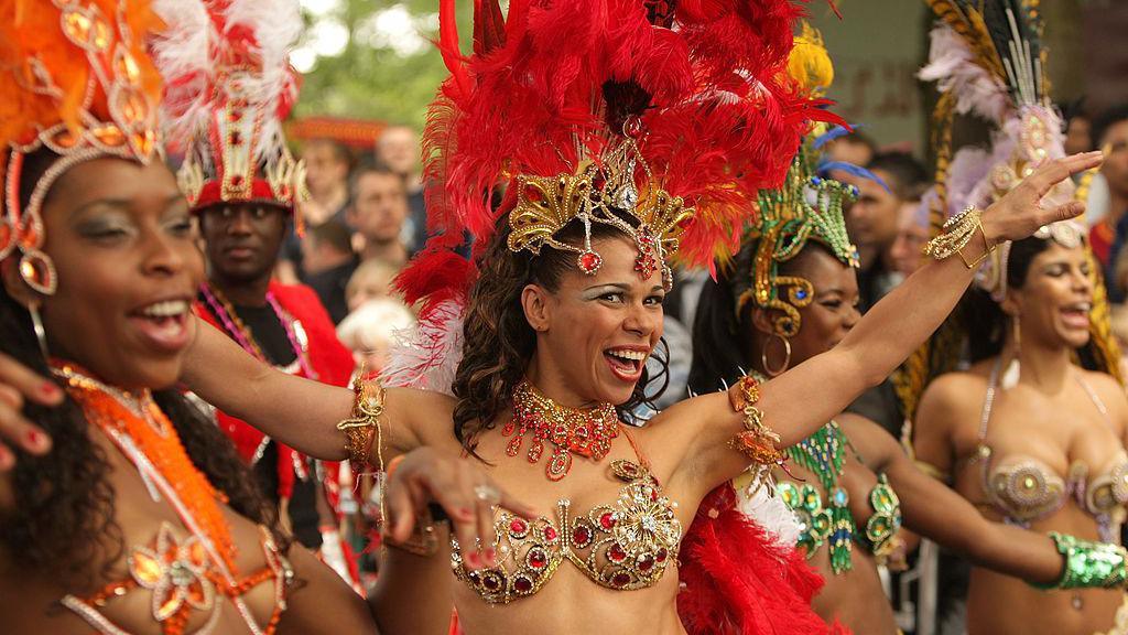 Smiling and dancing carnival performers with colourful outfits