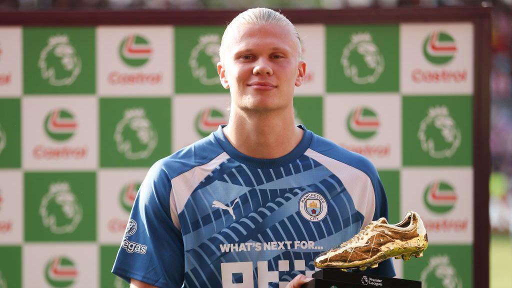 Erling Haaland holding the golden boot trophy