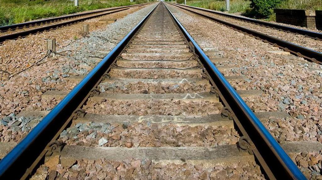 Rail tracks from close up, disappearing into horizon.