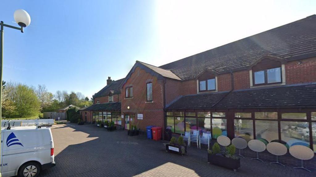 Rainbows Hospice which consists of a red brick building, with blue sky in the background