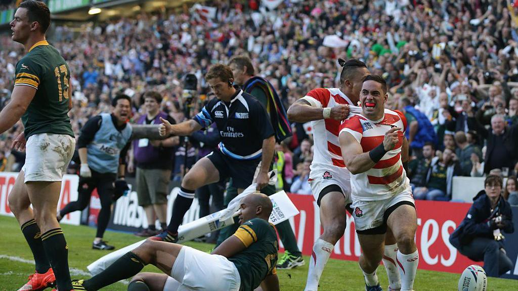 Japan celebrate after scoring the winning try against England