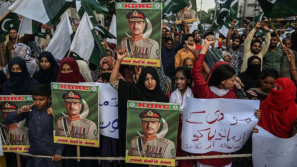 Protesters hold Pakistan flags and posters of Field Marshal Munir during an anti-India protest in Karachi on 2 May 