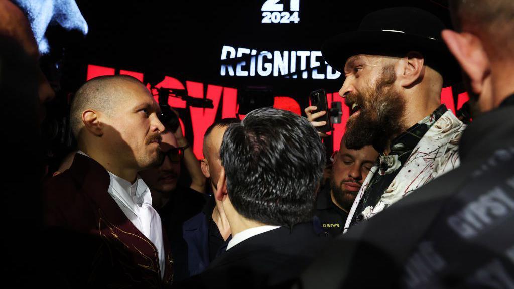 Oleksandr Usyk and Tyson Fury face off, with Mauricio Sulaiman
trying to get them to separate 