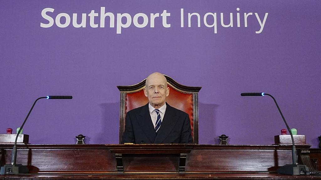 Southport Inquiry chairman Sir Adrian Fulford sitting inside the hearing room at Liverpool Town Hall