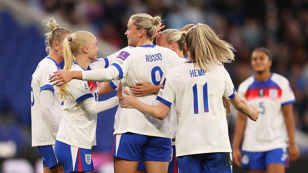 England players celebrate in a huddle