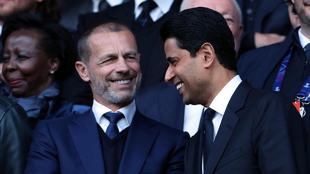 Uefa president Aleksander Ceferin and Paris Saint-Germain president Nasser Al-Khelaifi smile together in the stands at a football match