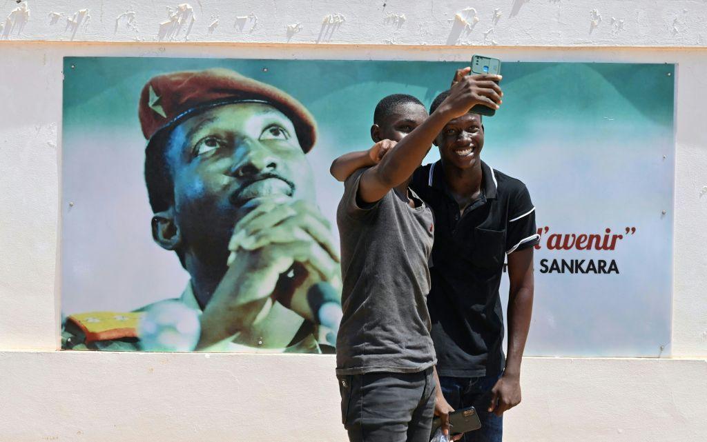 Students dressed in black take a selfie next to an image of Thomas Sankara, a pan-Africanist icon, at the University Thomas Sankara near Ouagadougou in Burkina Faso on 15 October 2021