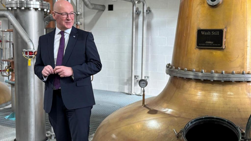 john swinney next to whisky still