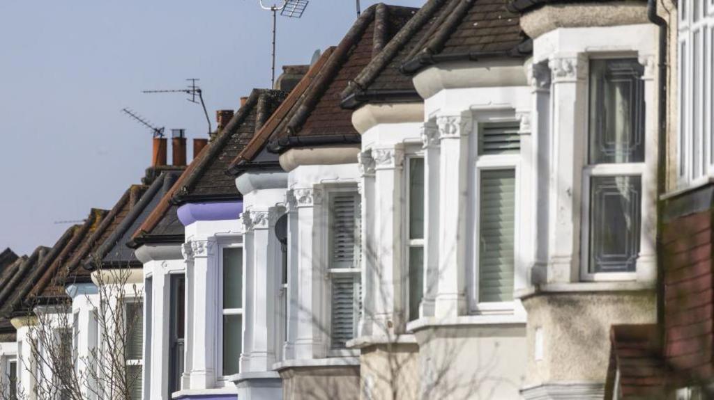 Close up of the upper bay windows of a row of terraced houses in London. 