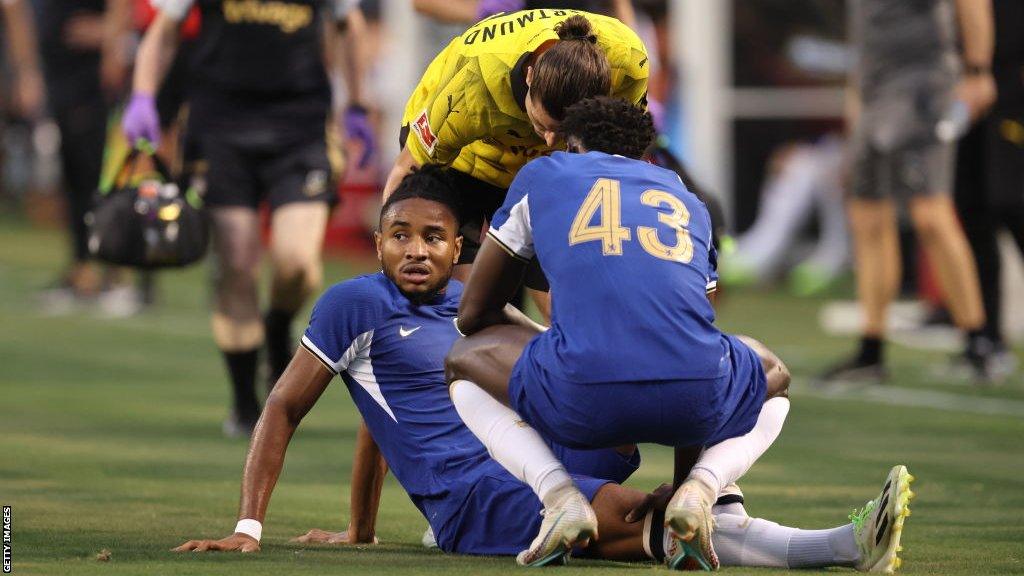 Christopher Nkunku sits on the floor after suffering an injury