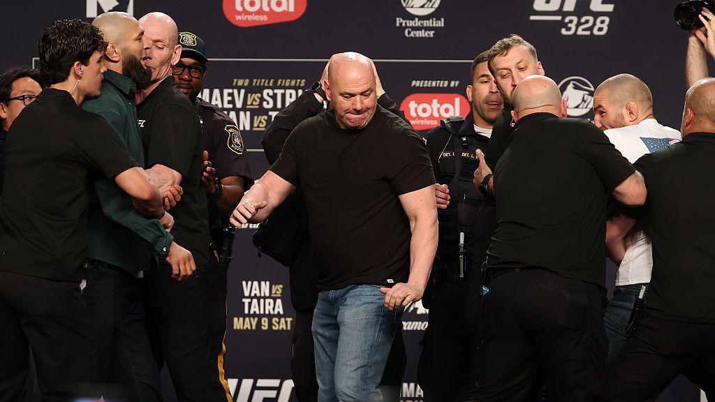 Sean Strickland and Khamzat Chimaev are held back by security at a UFC 328 news conference