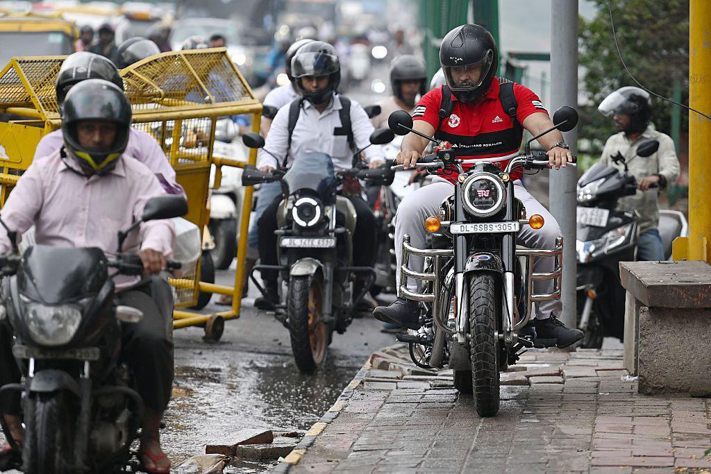A  motorist riding on a pedestrian footpath along a bridge in New Delhi. 