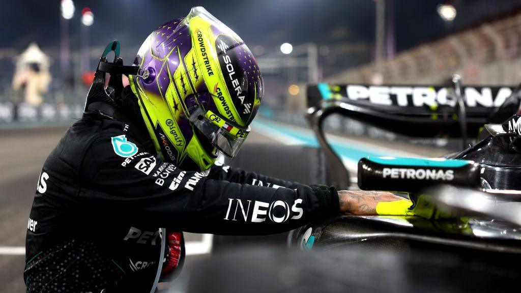 Lewis Hamilton kneels by his Mercedes at the end of the Abu Dhabi Grand Prix 