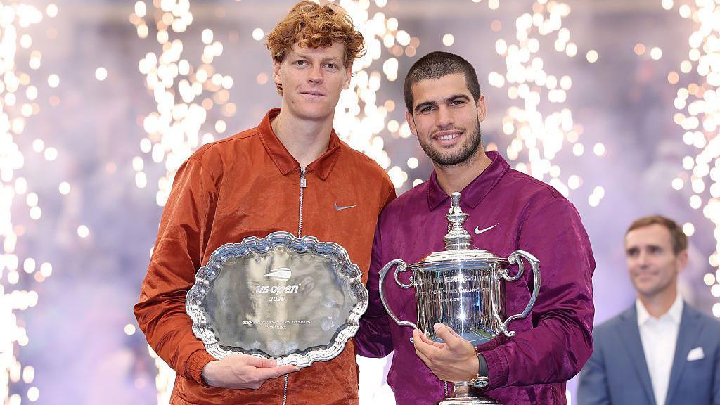 Runner-up Jannik Sinner and champion Carlos Alcaraz pose with their trophies after the 2025 US Open men's singles final