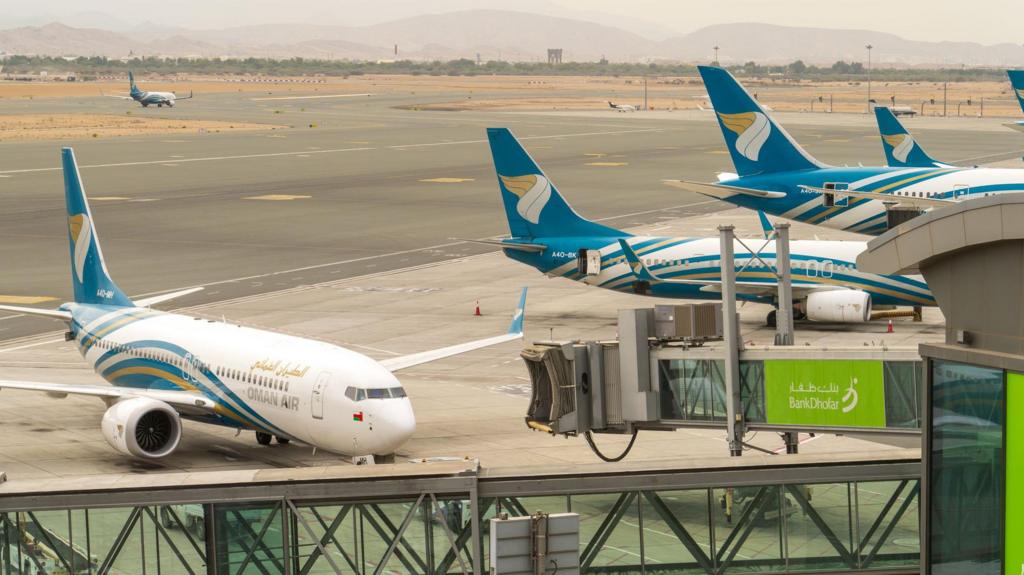 Oman Air planes lined up at an airport