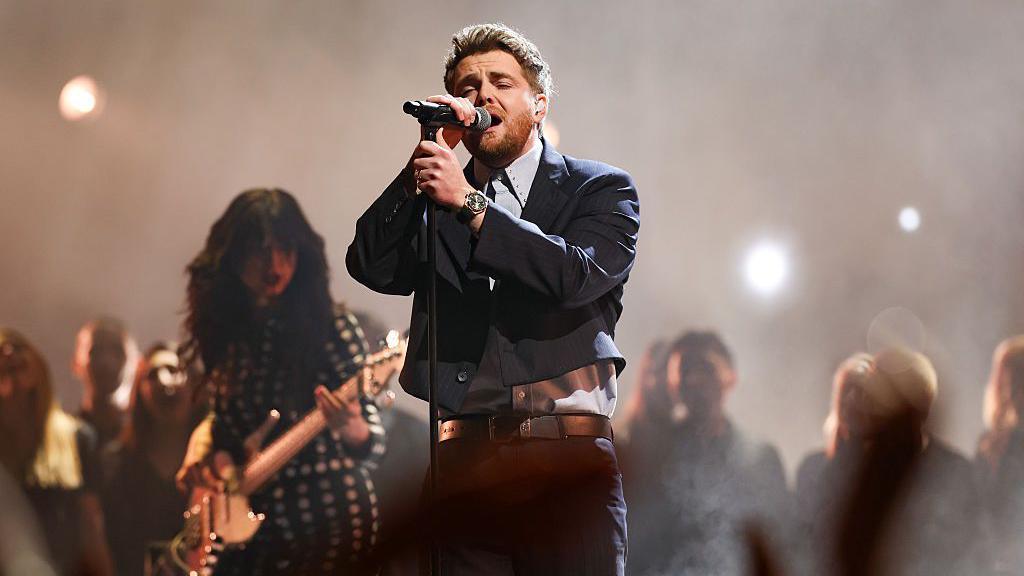 alex warren singing on stage into a microphone