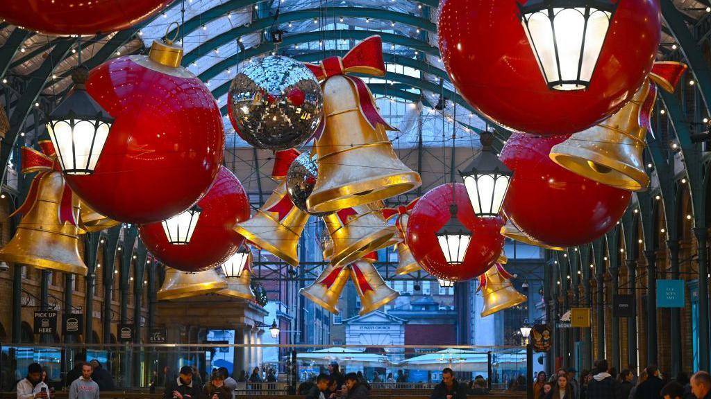 Giant bells and giant baubles hang from the ceiling 