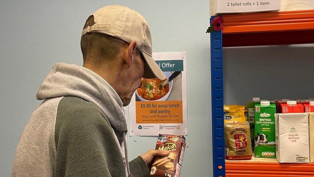 Man looks at food on a shelf