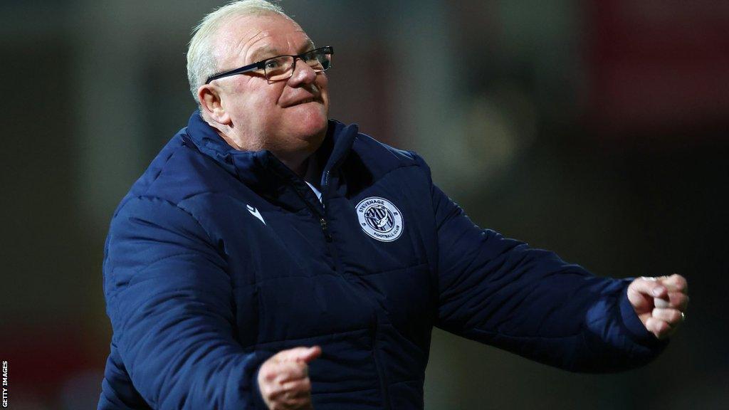 Steve Evans pumps his fists to the Stevenage fans after their 1-0 win at Swindon on Tuesday