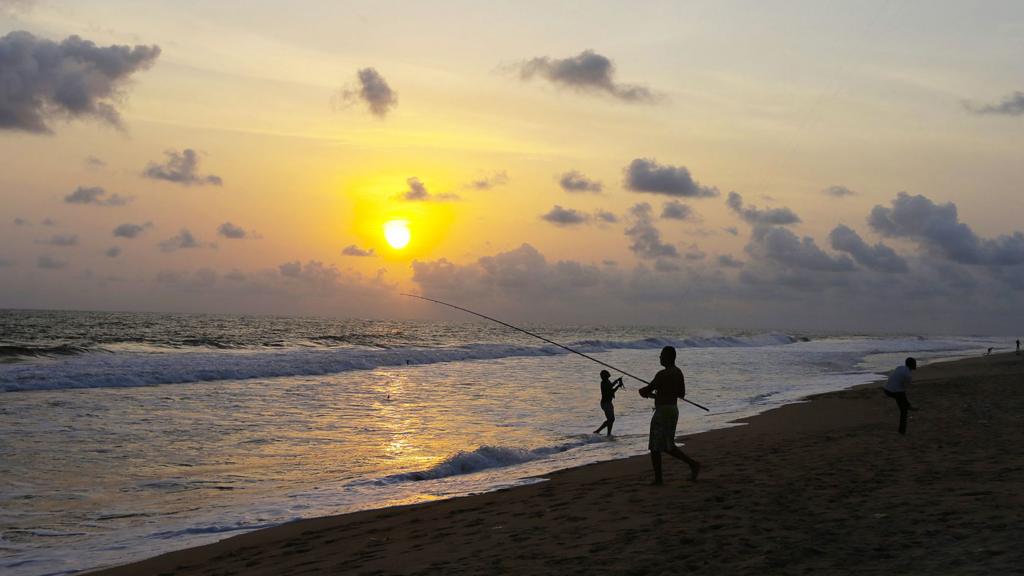 Fishermen at sunset on a beach in Grand Bassam, Ivory Coast - November 2016