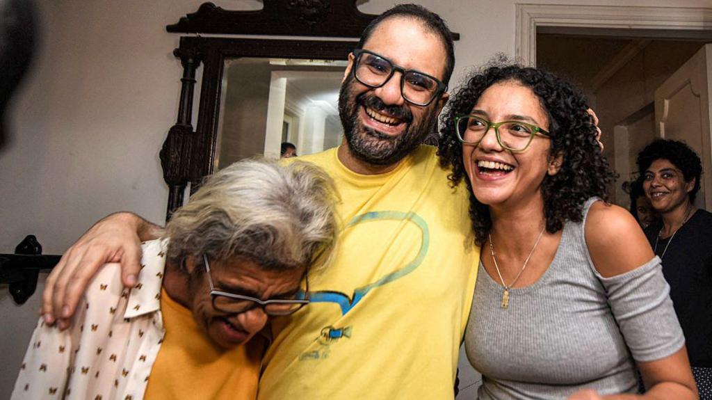 British-Egyptian activist Alaa Abdel Fattah (C) embraces his mother, writer Laila Soueif (L), and his sister Sanaa Seif (R), at home after his release in Cairo on September 23, 2025.