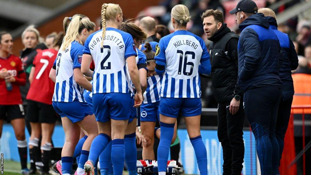 Mikey Harris speaks with Brighton's players during the match