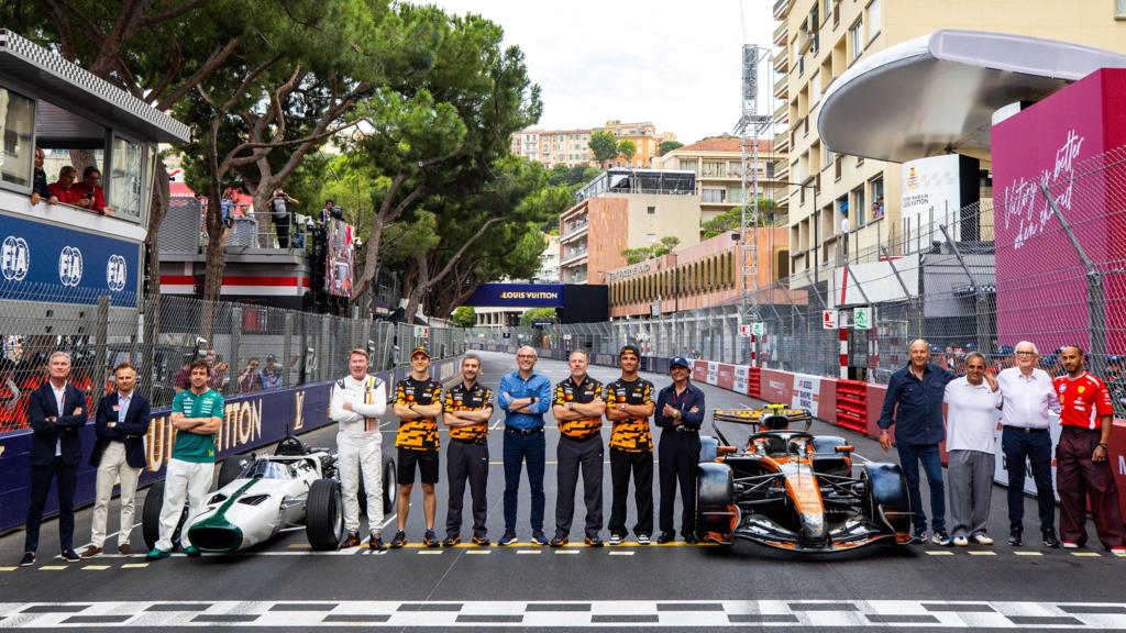 Past McLaren race winners - among them David Coulthard, Fernando Alonso, Mika Hakkinen and Lewis Hamilton - line up on the Monaco grid among team members to celebrate their 1,000th grand prix in Formula 1