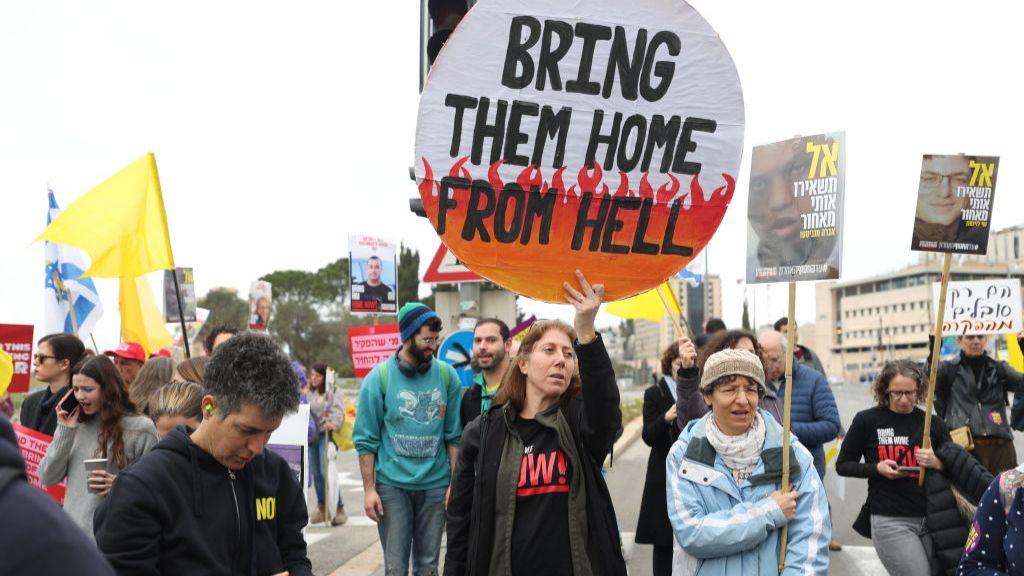 Relatives of Israeli hostages and their supporters, holding banners, flags and photos, gather outside the Israeli Prime Minister's Office to demand the government complete the prisoner exchange agreement with Palestinians in West Jerusalem on February 11, 2025